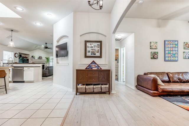 5204 Balsam Dr, Mckinney, TX 75071 - living area featuring vaulted ceiling, light wood-type flooring, baseboards, arched walkways, and ceiling fan