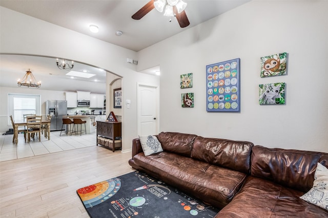 5204 Balsam Dr, Mckinney, TX 75071 - living room with light wood-style flooring, arched walkways, and ceiling fan with notable chandelier