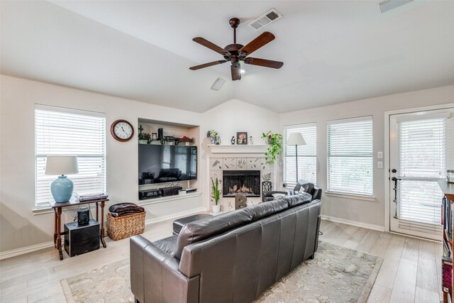 5204 Balsam Dr, Mckinney, TX 75071 - living room with visible vents, ceiling fan, a tiled fireplace, lofted ceiling, and light wood-type flooring