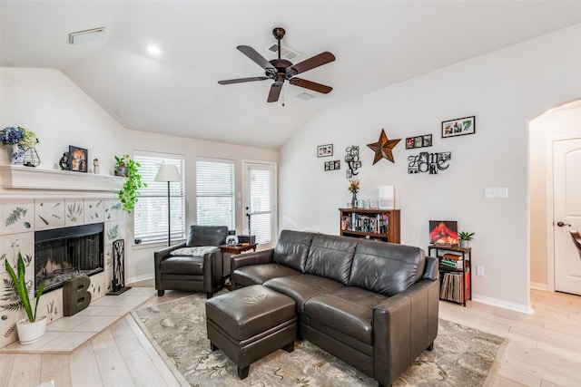 5204 Balsam Dr, Mckinney, TX 75071 - living area with a tile fireplace, ceiling fan, wood finished floors, arched walkways, and lofted ceiling