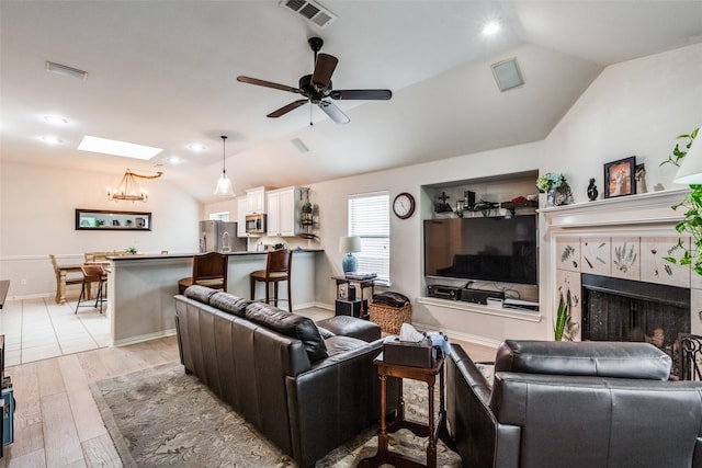 5204 Balsam Dr, Mckinney, TX 75071 - living room featuring a tiled fireplace, lofted ceiling, light wood finished floors, and visible vents