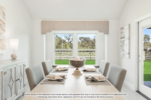 dining room featuring plenty of natural light and vaulted ceiling