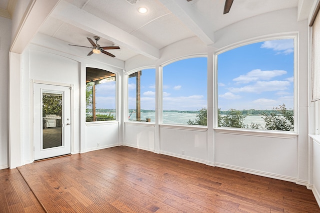 unfurnished sunroom featuring ceiling fan, beamed ceiling, and a water view