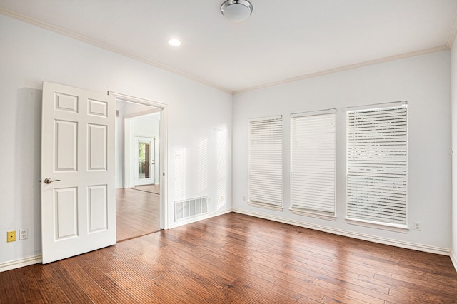 unfurnished room featuring wood-type flooring and ornamental molding