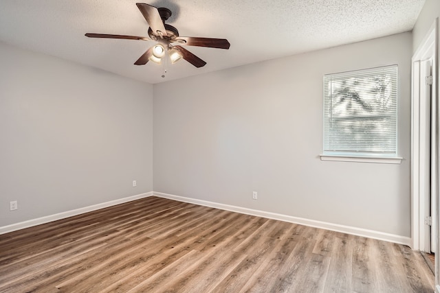 empty room with ceiling fan, hardwood / wood-style flooring, and a textured ceiling