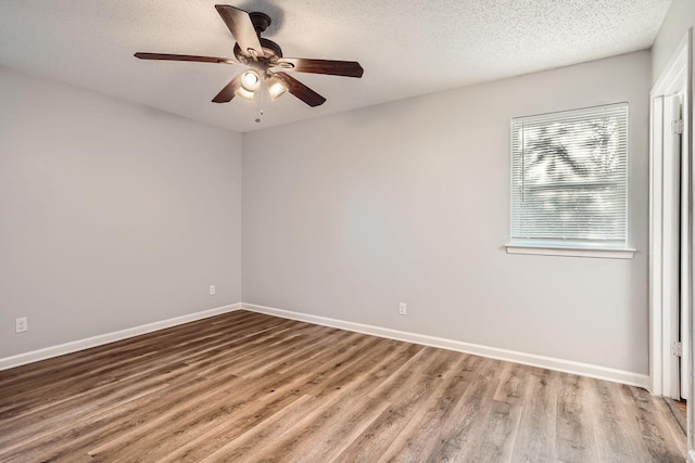 unfurnished room featuring ceiling fan, wood finished floors, baseboards, and a textured ceiling