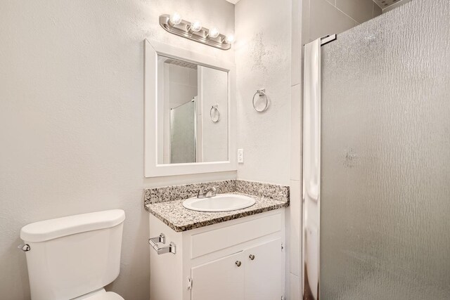 bathroom with vanity, toilet, and an enclosed shower