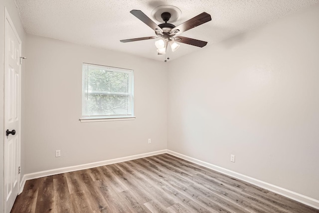 unfurnished room featuring ceiling fan, baseboards, a textured ceiling, and wood finished floors