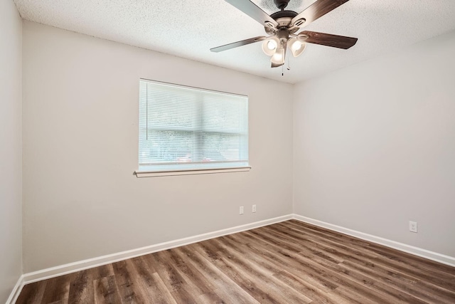 unfurnished room with wood finished floors, baseboards, and a textured ceiling