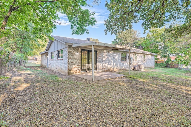 back of property with a patio, a yard, a fenced backyard, brick siding, and board and batten siding