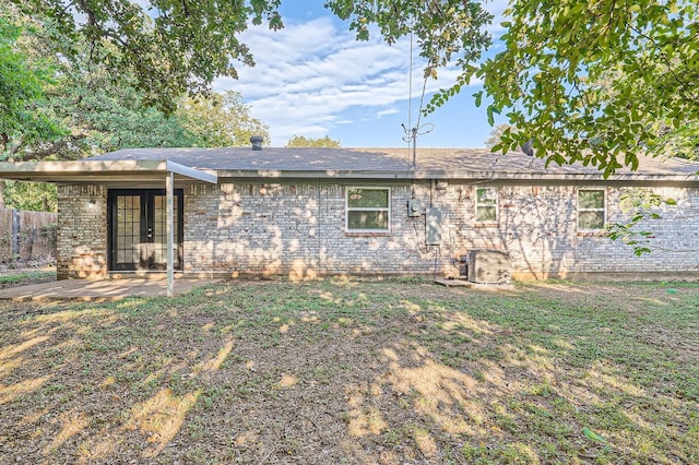 rear view of house featuring french doors, fence, brick siding, and a patio area
