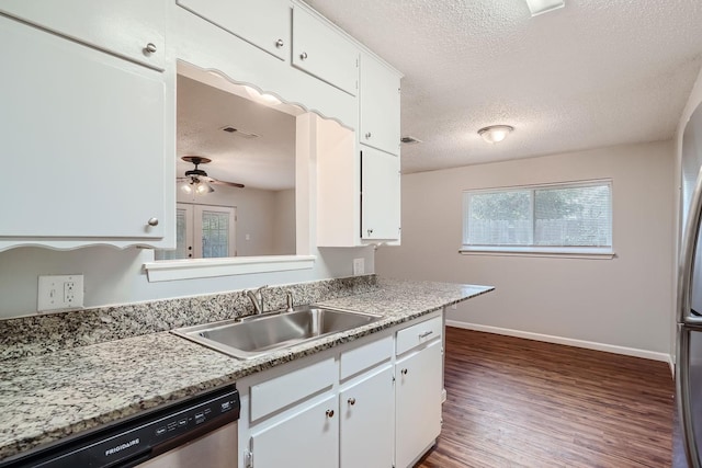 kitchen with stainless steel dishwasher, light countertops, white cabinets, and a sink