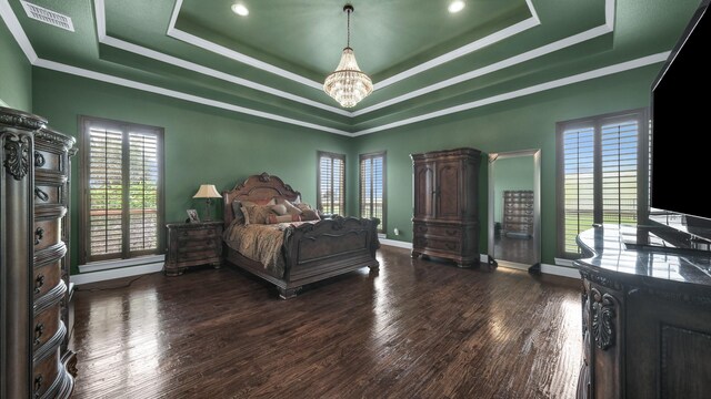 bedroom with ornamental molding, dark wood-type flooring, a raised ceiling, and an inviting chandelier