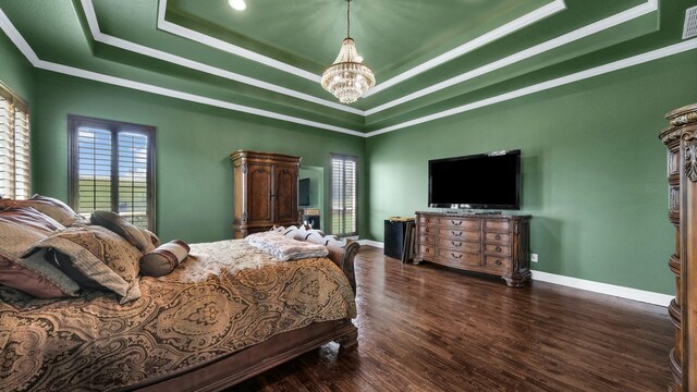 bedroom featuring a tray ceiling, ornamental molding, a chandelier, and dark hardwood / wood-style floors