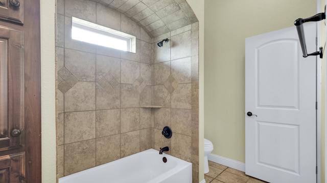 bathroom featuring toilet, tile patterned floors, and tiled shower / bath