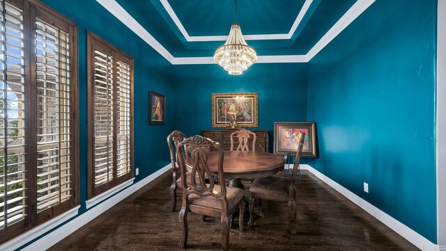 dining space featuring dark hardwood / wood-style flooring, a raised ceiling, and a notable chandelier