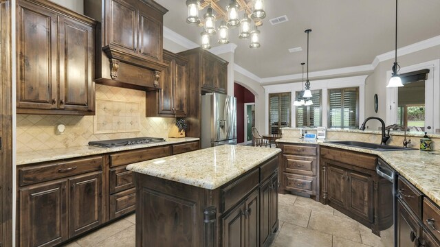 kitchen with an inviting chandelier, a center island, stainless steel appliances, sink, and hanging light fixtures