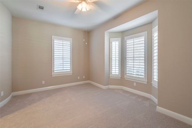 carpeted spare room with ceiling fan