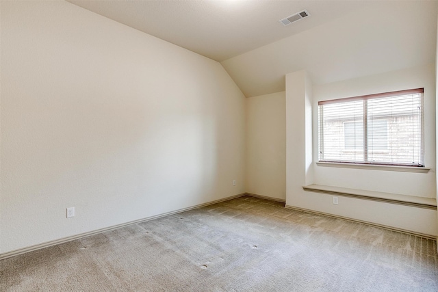 empty room featuring light carpet and vaulted ceiling