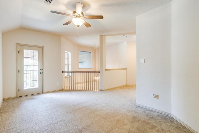 empty room with ceiling fan, light colored carpet, and vaulted ceiling