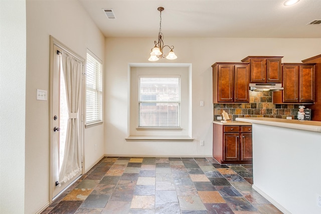 kitchen with backsplash, a chandelier, and hanging light fixtures