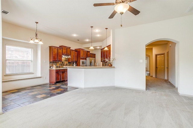 kitchen featuring ceiling fan with notable chandelier, appliances with stainless steel finishes, light colored carpet, and decorative light fixtures