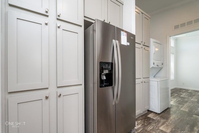 kitchen with white cabinetry, dark hardwood / wood-style floors, stacked washer / drying machine, and stainless steel fridge with ice dispenser