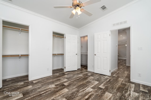 unfurnished bedroom with crown molding, multiple closets, vaulted ceiling, dark wood-type flooring, and ceiling fan