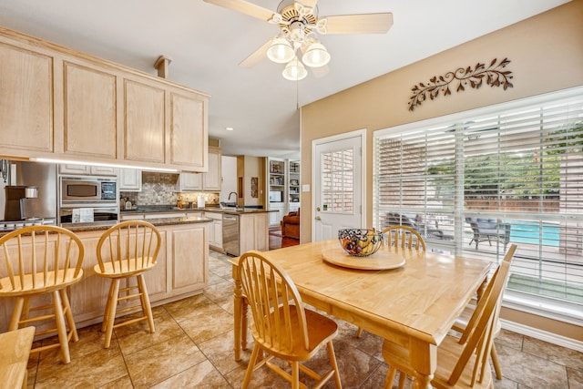 dining room featuring ceiling fan, sink, and a healthy amount of sunlight