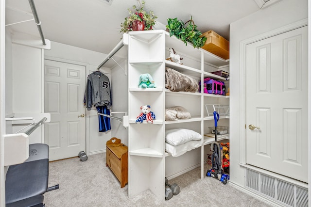 walk in closet featuring light colored carpet