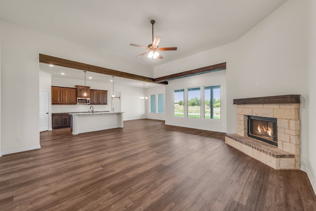 unfurnished living room featuring ceiling fan, a fireplace, and dark hardwood / wood-style floors