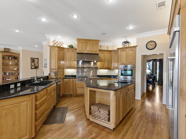 kitchen with dark stone countertops, light hardwood / wood-style flooring, sink, extractor fan, and ornamental molding