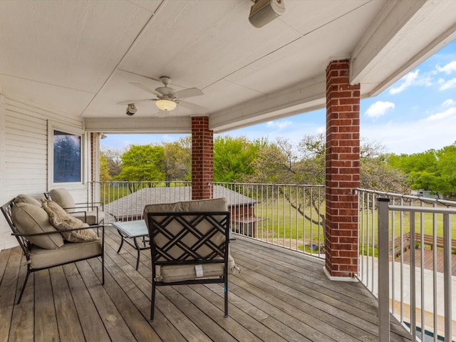 wooden terrace featuring an outdoor living space and ceiling fan