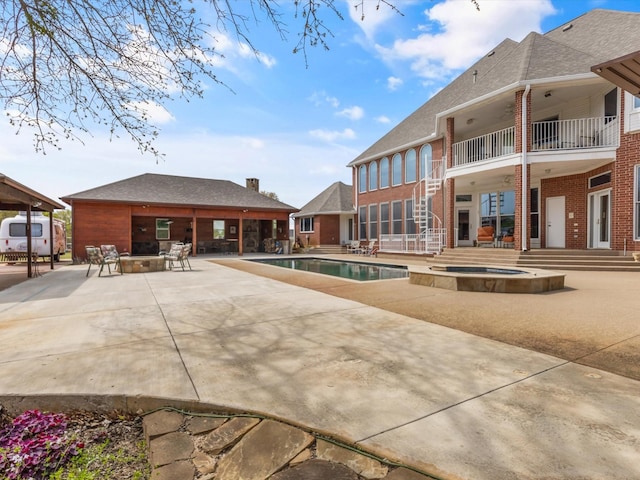 view of pool with a pool with connected hot tub and a patio area