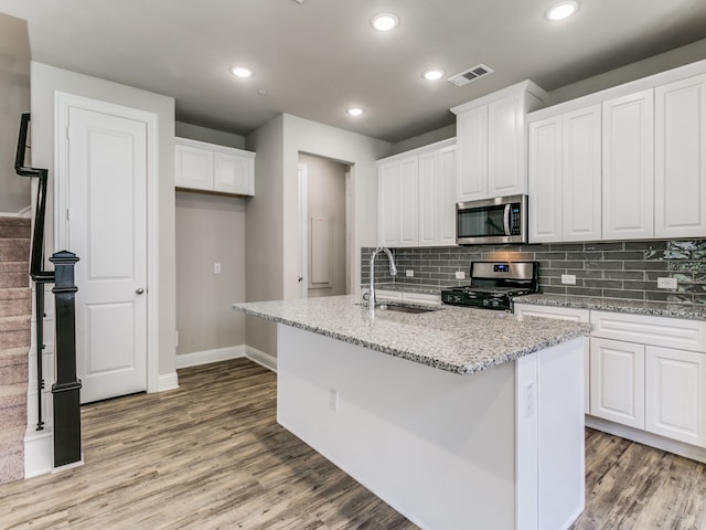 kitchen featuring white cabinetry, an island with sink, stainless steel appliances, and sink