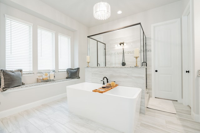 bathroom with baseboards, a freestanding bath, an inviting chandelier, recessed lighting, and a stall shower