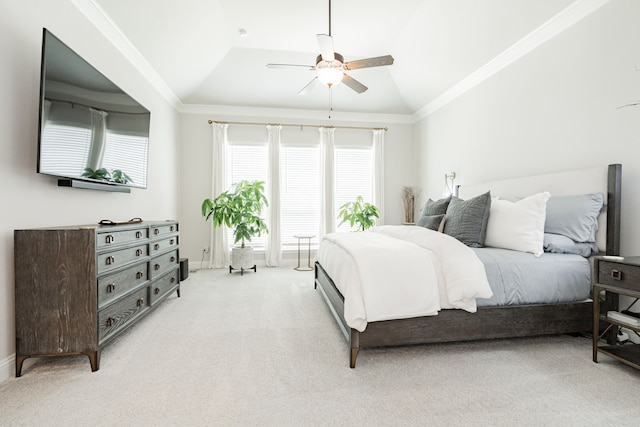 carpeted bedroom featuring crown molding, lofted ceiling, a tray ceiling, and ceiling fan