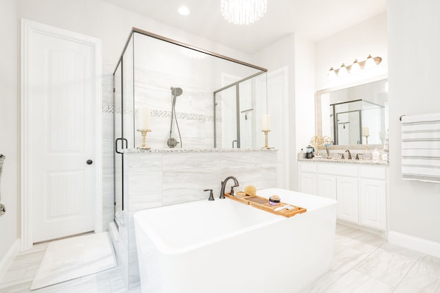 bathroom with a freestanding bath, vanity, and a stall shower