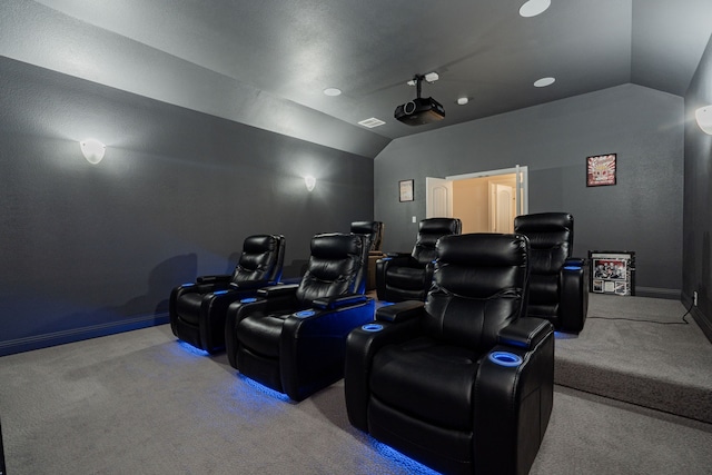 carpeted home theater with vaulted ceiling