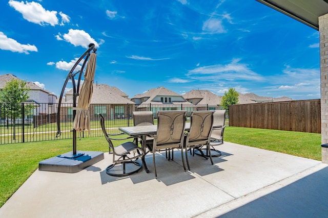 view of patio with fence, a residential view, and outdoor dining area