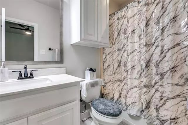 full bathroom with vanity, ceiling fan, toilet, and plus walk in shower