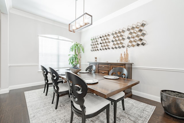 dining space with crown molding, wood finished floors, baseboards, and a notable chandelier