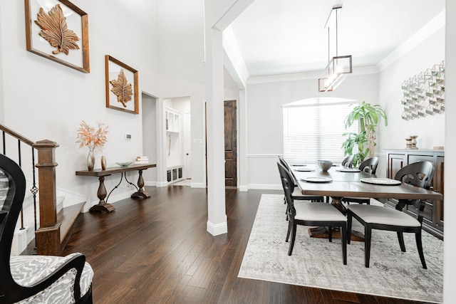 dining space with baseboards, ornamental molding, and dark wood finished floors