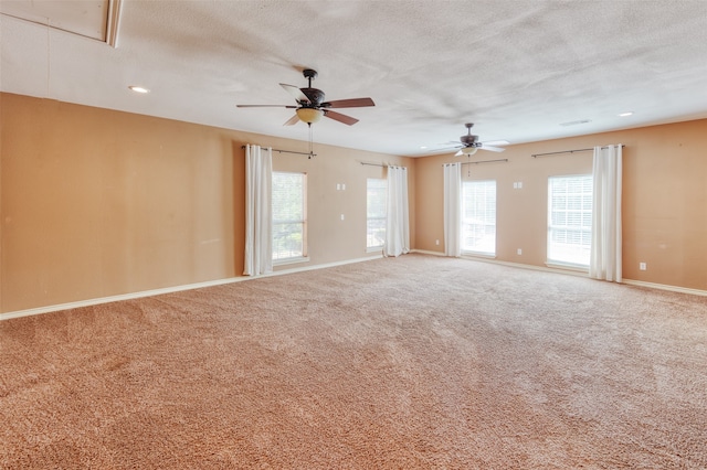 empty room with ceiling fan, carpet floors, and a healthy amount of sunlight