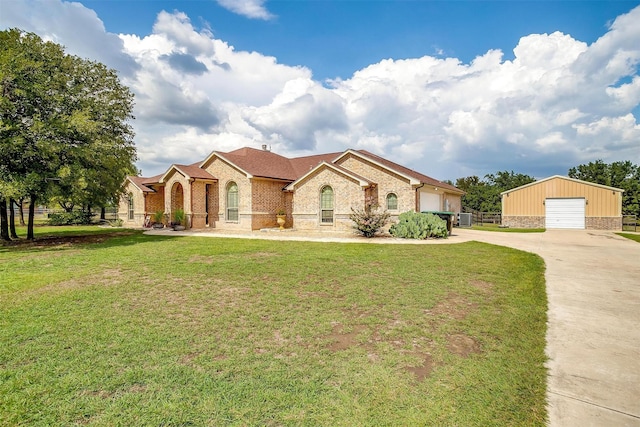 view of front facade with a garage, brick siding, an outdoor structure, and a front lawn