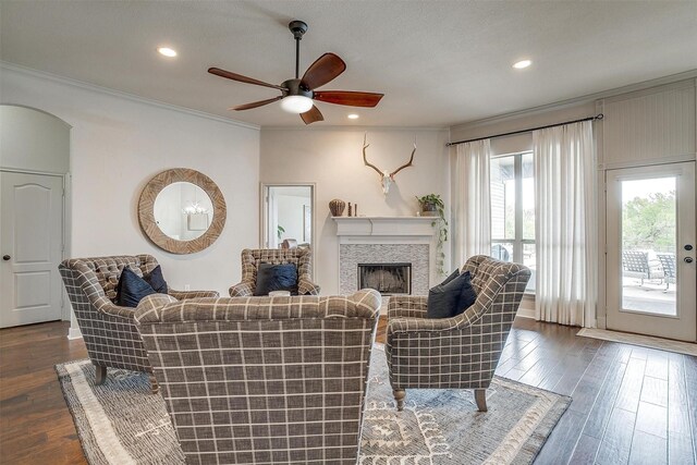 living room featuring ceiling fan, dark hardwood / wood-style flooring, and ornamental molding