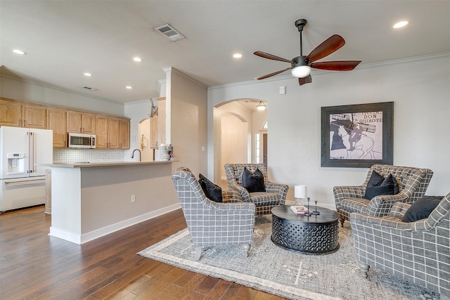 living room featuring ornamental molding, sink, ceiling fan, and dark hardwood / wood-style floors