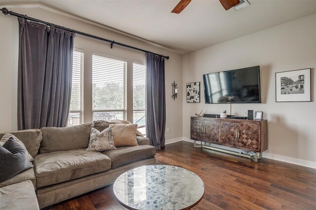 living room with dark wood-type flooring, ceiling fan, lofted ceiling, and a healthy amount of sunlight