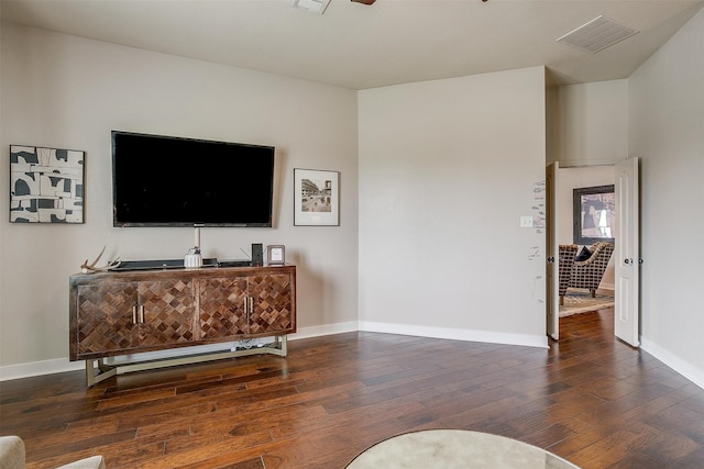 living room featuring ceiling fan and dark hardwood / wood-style floors