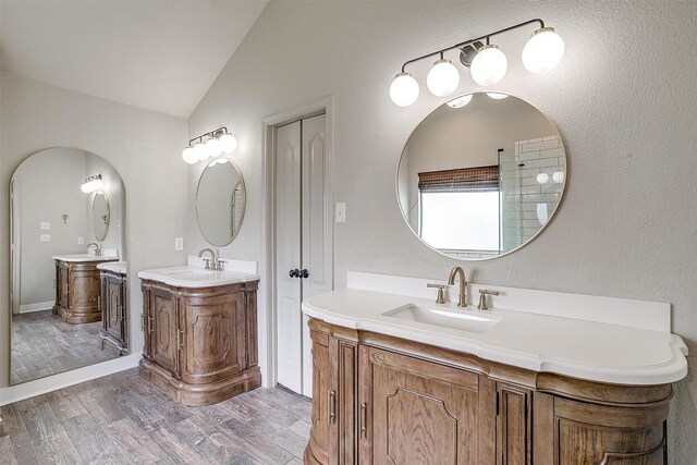 bathroom with vanity, vaulted ceiling, and wood-type flooring